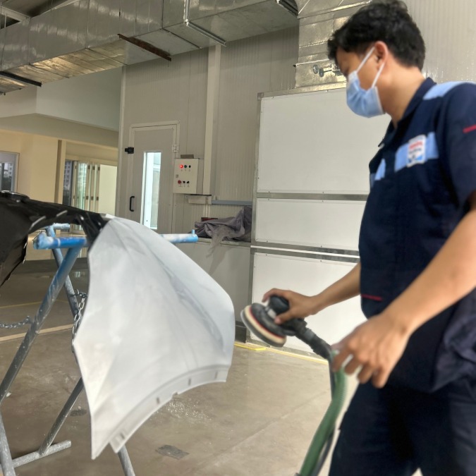 Teknisi sedang bekerja pada panel mobil di bengkel